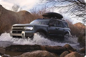Ford Bronco Sport driving through water on a rugged trail