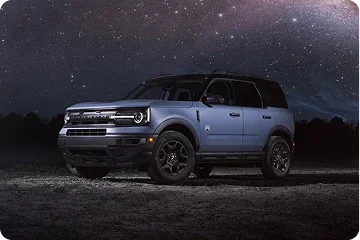Ford Bronco parked under a night sky