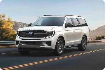 White Ford Expedition driving on a road