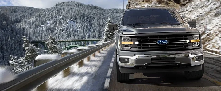 Ford F-150 driving on a snowy mountain road