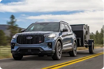 Ford Explorer towing a small utility trailer on a road