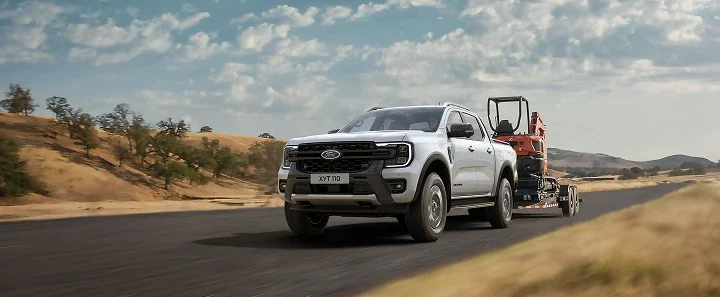 Ford pickup towing equipment on an open road