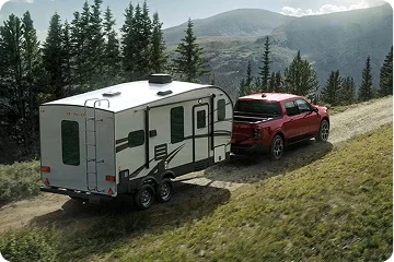 Ford Maverick towing a small camper on a mountain road