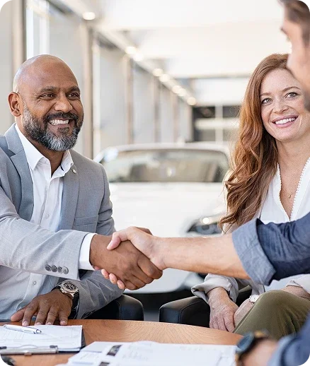 Customer shaking hands with a dealership consultant during a Ford financing discussion