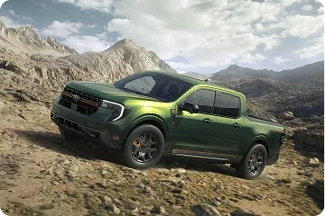 Green Ford Maverick driving on a rugged mountain trail