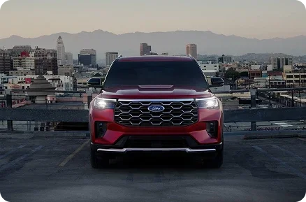 Red Ford Explorer parked on a rooftop deck above a city skyline