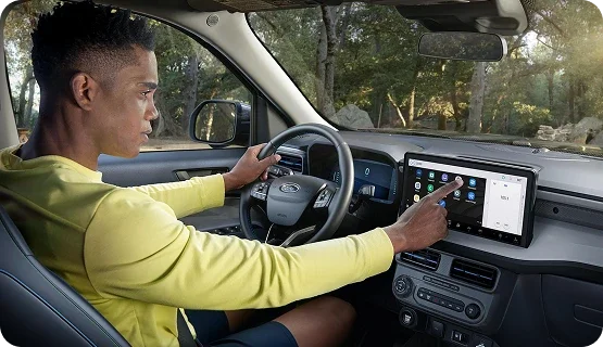 Driver using the SYNC touchscreen inside a Ford Maverick