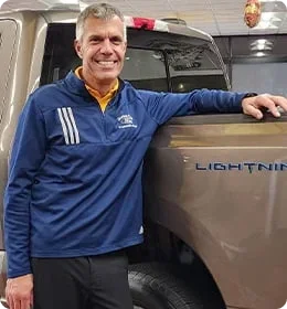 Dorian Ford EV specialist standing beside a Ford F-150 Lightning