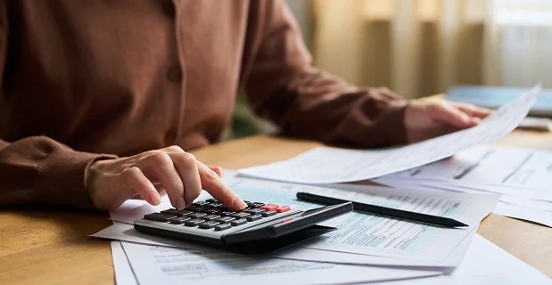 Business owner reviewing finances with a calculator