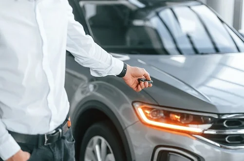 Vehicle owner holding the keys to a car ready to sell