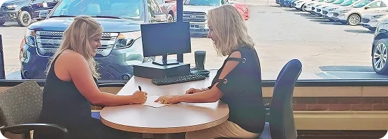 A Dorian Ford team member reviews a written offer with a customer