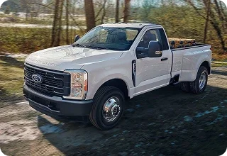 White Ford Super Duty Regular Cab on a dirt road