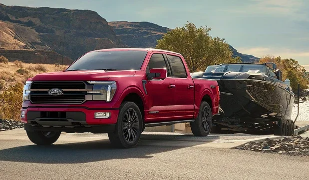 Red Ford F-150 towing a boat on a trailer