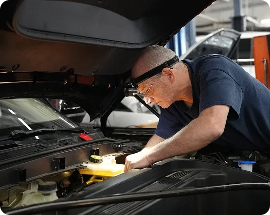 Ford technician working under the hood of a vehicle