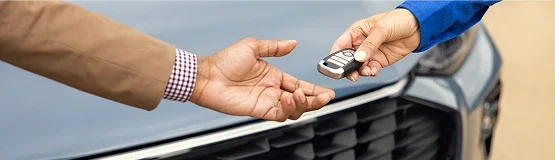 Customer handing a Ford key fob to a service technician