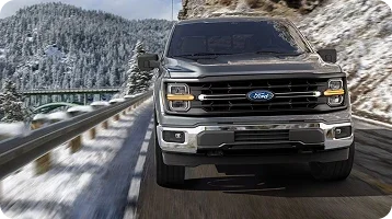 Gray Ford Super Duty driving on a snowy mountain road