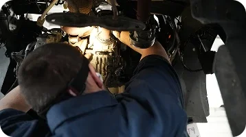 Dorian Ford technician working beneath a vehicle in the on-site, Ford-approved collision center