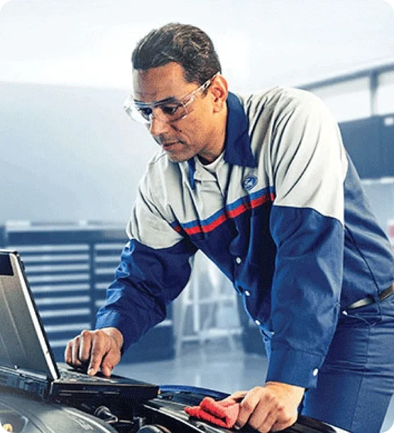 Ford technician using diagnostic equipment to inspect a vehicle