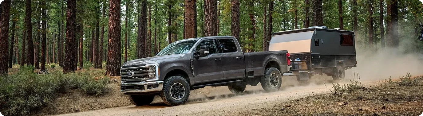2026 Ford Super Duty towing a trailer on a forest road